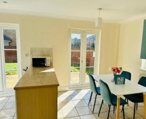 a kitchen with a counter and a table and chairs at Detached Three Bedroom House in Ashford Secure Area in Kent
