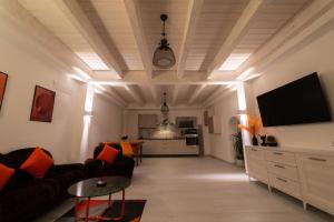 Una sala de estar con un sofá y un televisor de pantalla plana. en La Suite Di Giovina by VILLA YUCCA, en Torano Nuovo
