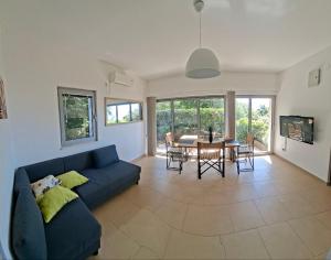 un salon avec un canapé bleu et une table dans l'établissement Acacia Hill olive tree apartment, à Herceg-Novi