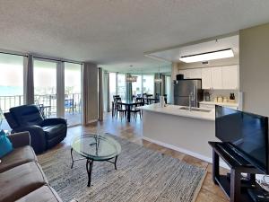 a living room with a couch and a table and a kitchen at Santa Rosa Dunes #1022 in Pensacola Beach
