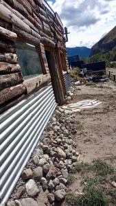 a building with a window and a pile of rocks at Cabaña el ojo de Horus el chalten santa cruz in El Chalten