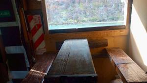 two wooden benches in a room with a window at Cabaña el ojo de Horus el chalten santa cruz in El Chalten +2 photos