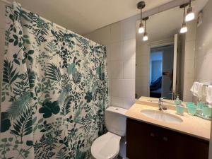 ein Badezimmer mit Duschvorhang, Toilette und Waschbecken in der Unterkunft Depto familiar en Barrio Italia - 1100 LB in Santiago