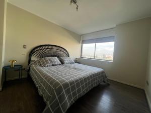ein Schlafzimmer mit einem Bett und einem Fenster mit Aussicht in der Unterkunft Depto familiar en Barrio Italia - 1100 LB in Santiago