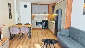 Una cocina y una sala de estar con un sofá y una mesa. en Chic, Sunny and Cozy One Bedroom Bliss, en Varna