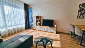 Una sala de estar con un sofá y un televisor. en Chic, Sunny and Cozy One Bedroom Bliss, en Varna