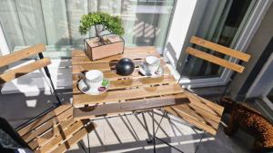 una mesa de madera con una planta en el balcón en Chic, Sunny and Cozy One Bedroom Bliss, en Varna