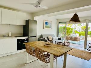 a kitchen and living room with a wooden table and chairs at Coco Beach 2 bedrooms beachfront in Baie Nettle