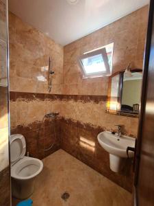 a bathroom with a toilet and a sink at Guest House Rustaveli in K'obulet'i +141 photos