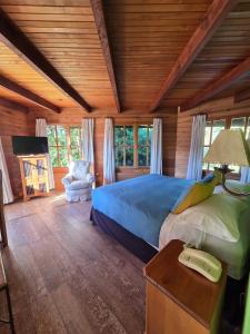um quarto com uma cama num quarto com tectos em madeira em Hotel Malalhue em Pucón