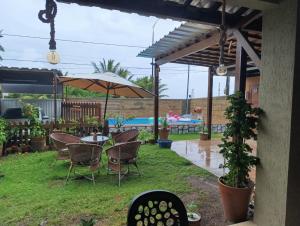 a patio with a table and chairs and an umbrella at Pousada Espaco Luz do Sol Beira-Mar in João Pessoa