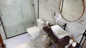 ein Badezimmer mit Toilette, Waschbecken und Spiegel in der Unterkunft Chalé Luz do Luar Romantismo e uma linda vista in Campos do Jordão + 24 Fotos