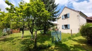 a house with a tree and a blue fence at Gîte Elendil - Esprit Champêtre in Chambon