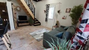 a living room with a couch and a staircase at Gîte Elendil - Esprit Champêtre in Chambon
