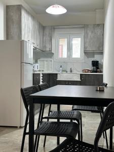 a kitchen with a table and chairs and a refrigerator at Tsakalos Apartments in Edipsos