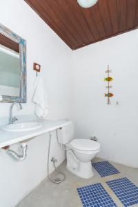 a bathroom with a white toilet and a sink at Casa Búzios Ama in Búzios