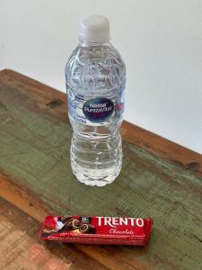 une bouteille d'eau et une barre chocolatée sur une table dans l'établissement Apartamento centro de Peruíbe, à Peruíbe