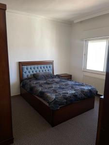 a bedroom with a bed and a window at شقة مفروشة للإيجار الجبيهة in Amman