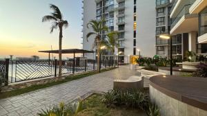 a walkway next to a beach with buildings and palm trees at Apartamento Frente al Mar D Lujo 901- Santa Marta in Playa Bello Horizonte