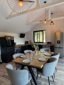 a dining room with a wooden table and chairs at Le Chalet belle Vue in Saint-Martin-de-la-Lieue