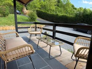 a patio with chairs and a table on a porch at Le Chalet belle Vue in Saint-Martin-de-la-Lieue