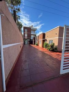 an empty sidewalk in front of a brick building at Apart Hotel BRIANA in Puerto Iguazú