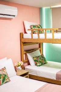 a room with three bunk beds and a table at Taybo Beach By St Hoteles in Santa Marta +45 photos