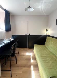 ein Schlafzimmer mit einem Bett, einem Schreibtisch und einem Tisch in der Unterkunft Studio en rdc - hyper centre Dol de Bretagne in Dol-de-Bretagne