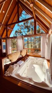 a large bath tub in a room with a large window at Pousada Vale da Neve in Urubici +59 photos