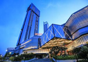 a large glass building with a tall building at Grand Sungkono Lagoon Apartment 2BR Surabaya by Le Ciel Hospitality in Surabaya