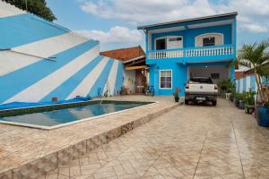 a blue house with a pool in front of it at Sobrado Azul com Piscina in Boituva