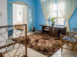 a living room with blue walls and a rug at Sobrado Azul com Piscina in Boituva