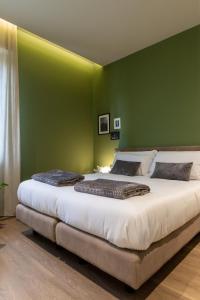 a bedroom with a large bed with a green wall at A CASA di LAURA in Bergamo