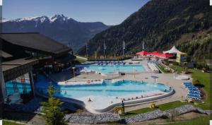 a large swimming pool in a resort in the mountains at Charmant petit appartement in Ovronnaz