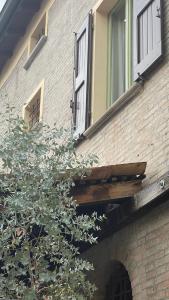 a brick building with an open window and a tree at Charming mini apartment-CasaNina in Rubiera +3 photos