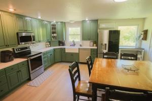 a kitchen with green cabinets and a table with chairs at Sundance Countryside Retreat in Sumner