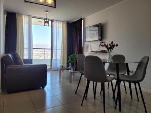 a living room with a table and chairs and a couch at Característico departamento 2 habitaciones, capacidad 4 y 5 personas, excelente vista de la ciudad y mar in Antofagasta