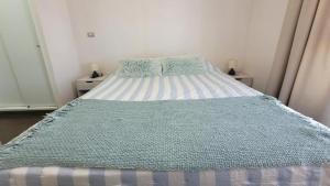 a bed with a blue and white comforter in a bedroom at Característico departamento 2 habitaciones, capacidad 4 y 5 personas, excelente vista de la ciudad y mar in Antofagasta