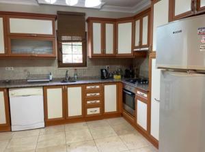 a kitchen with wooden cabinets and a white refrigerator at Villa Caretta Luna in Ortaca
