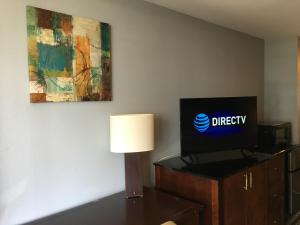 a room with a television and a lamp on a dresser at Safari Inn - Murfreesboro in Murfreesboro