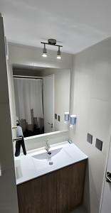 a bathroom with a sink and a large mirror at Exclusivo departamento tres dormitorios, capacidad 6 personas, excelente vista al mar para disfrutar de las puestas de sol in Antofagasta