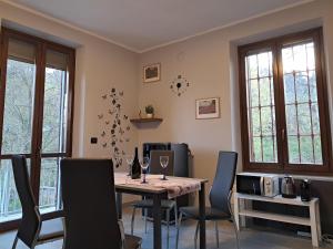 a dining room with a table and chairs and windows at Apartment Narzole LanghExplorer in Narzole