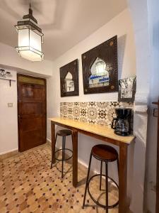 a kitchen with a wooden table and two bar stools at Mog'ador bleue in Essaouira +22 photos