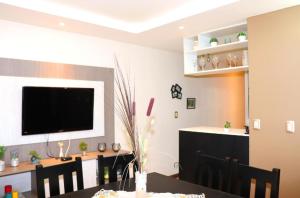 a dining room with a table and a television on a wall at Aires de Maipu in Maipú