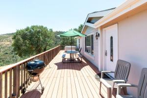 a deck with chairs and an umbrella and a grill at Mariposa Ridge Retreat in Mariposa