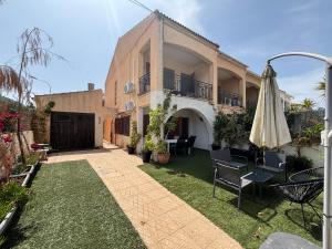 un patio al aire libre con sillas y sombrilla en Duplex adosado cerca de la playa puerto mazarron, en Puerto de Mazarrón