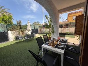 Una mesa con platos de comida en un patio. en Duplex adosado cerca de la playa puerto mazarron, en Puerto de Mazarrón