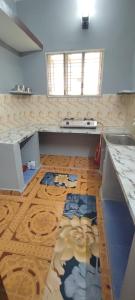 a kitchen with a sink and a wooden floor at Thillai Aura Homestay in Chidambaram
