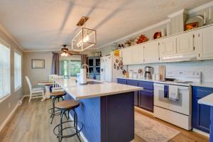 a kitchen with blue and white cabinets and a counter at Noteworthy Cabin Grill, Walk to Beaver Lake! in Rogers