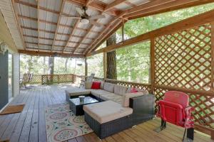 a screened in porch with a couch and a table at Noteworthy Cabin Grill, Walk to Beaver Lake! in Rogers